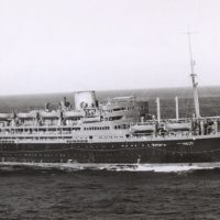 Die Dunera wurde 1937 von der British India Steam Navigation Company in Dienst gestellt. Der 157 Meter lange 11.161 BRT-Kreuzfahrtdampfer erreichte eine Spitzengeschwindigkeit von 16 Knoten (ca. 30 km/h). 290 Crewleute versorgten 104 Passagiere der ersten, 100 der zweiten und 164 der dritten Klasse. Die Zulassung als Truppentransporter ab 1939 lautete auf 1.157 Passagiere. Nach dem 2. Weltkrieg diente das Schiff bis 1960 der britischen Marine. 1961 wurde die Dunera für Bildungsfahrten von 834 Kindern umgebaut und 1967 verschrottet. Das Foto entstand 1940. Quelle: Australian War Museum Nr. 303219, Public Domain.